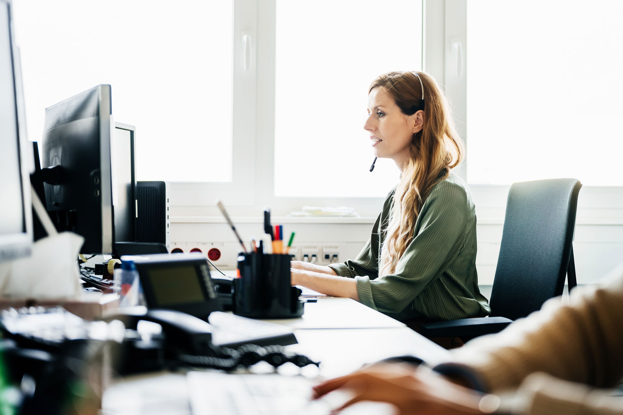 A claims-desk professional working assignments with a headset